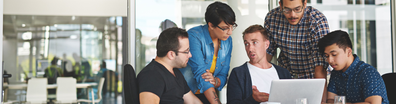 Group of people in office around a laptop