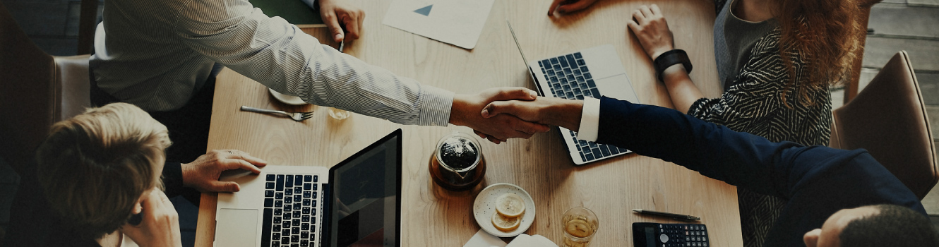 A birds-eye view of a handshake at a meeting